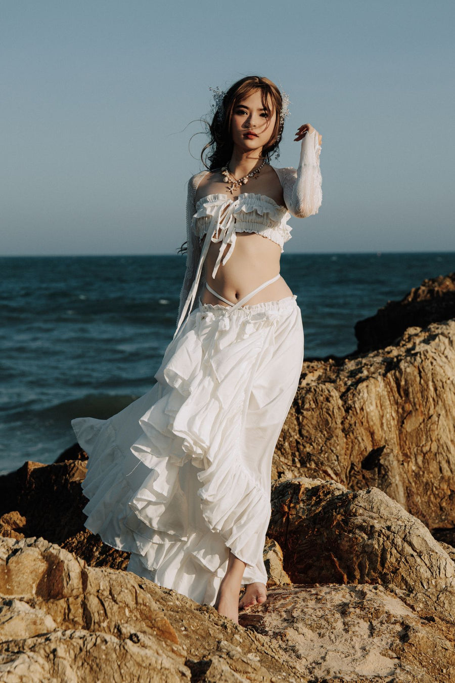 Mujer con vestido blanco junto al mar