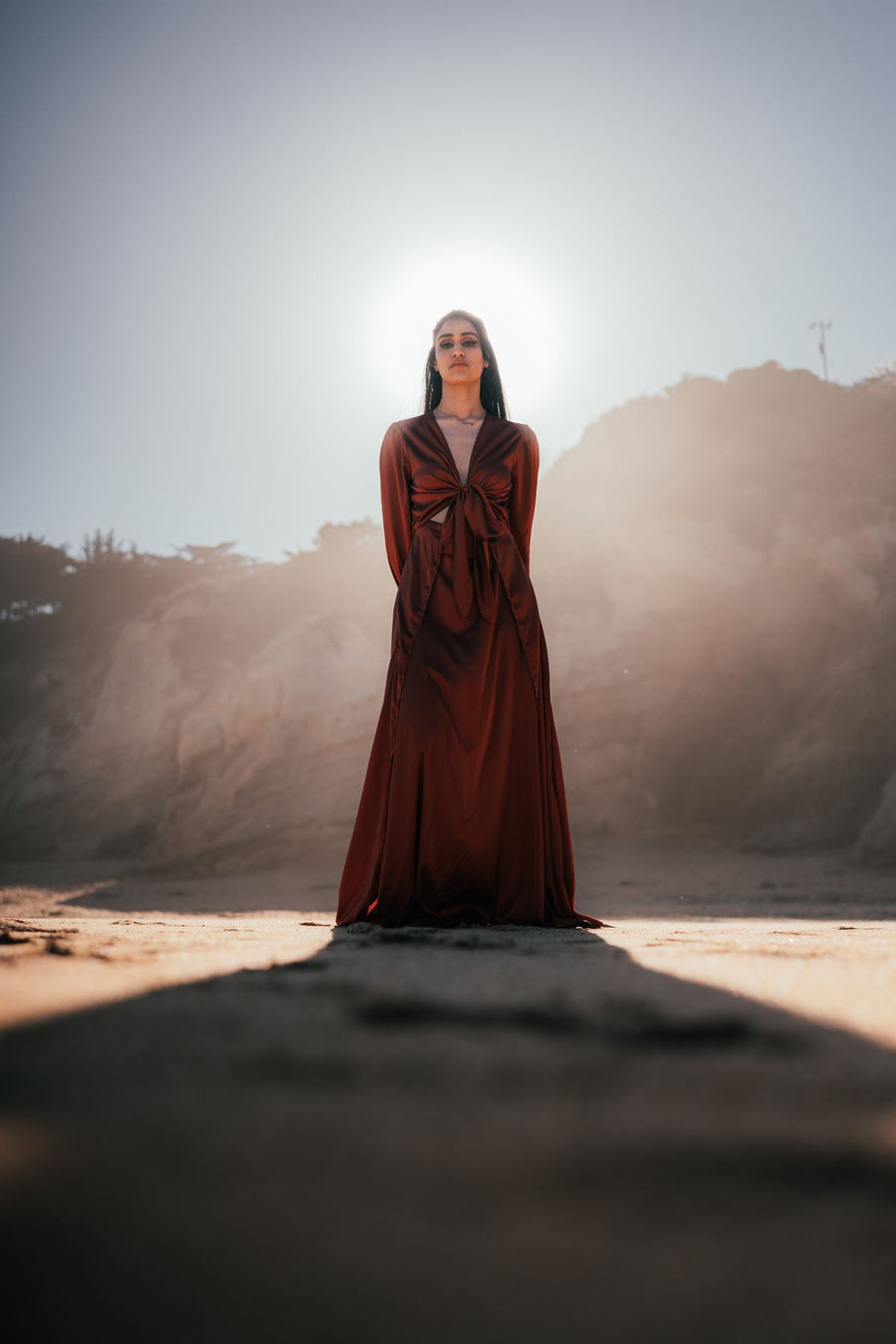 Mujer con vestido largo marrón en la playa