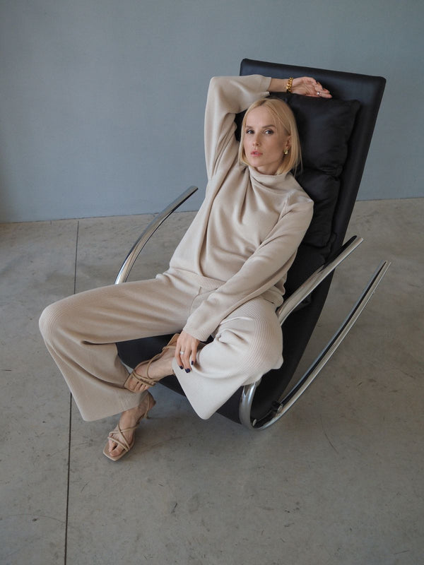 Mujer vestida de beige sentada en un sillón