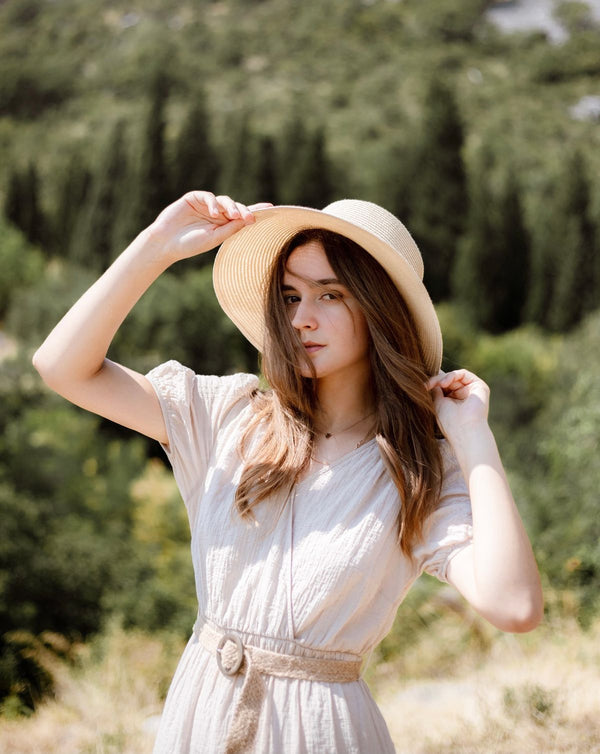 Mujer con vestido blanco de verano y sombrero